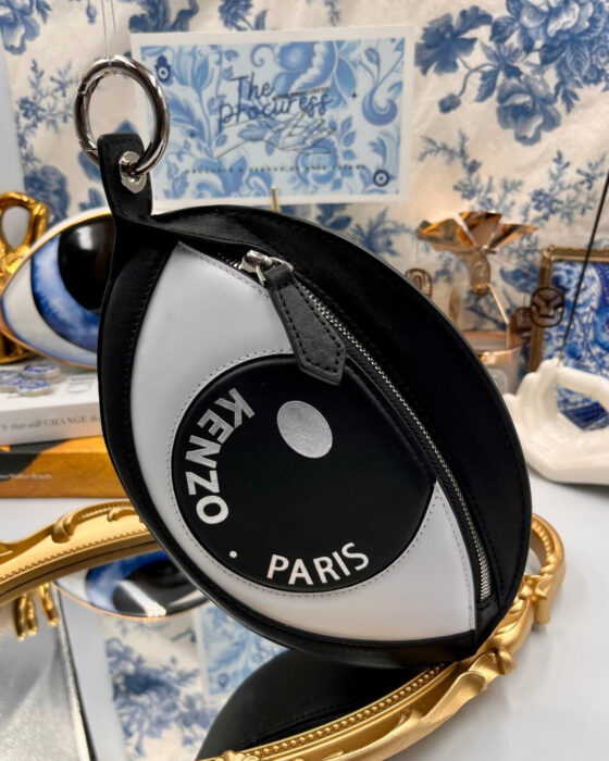 KENZO Kontact Eye leather clip pouch in black and white displayed in a decorative still life