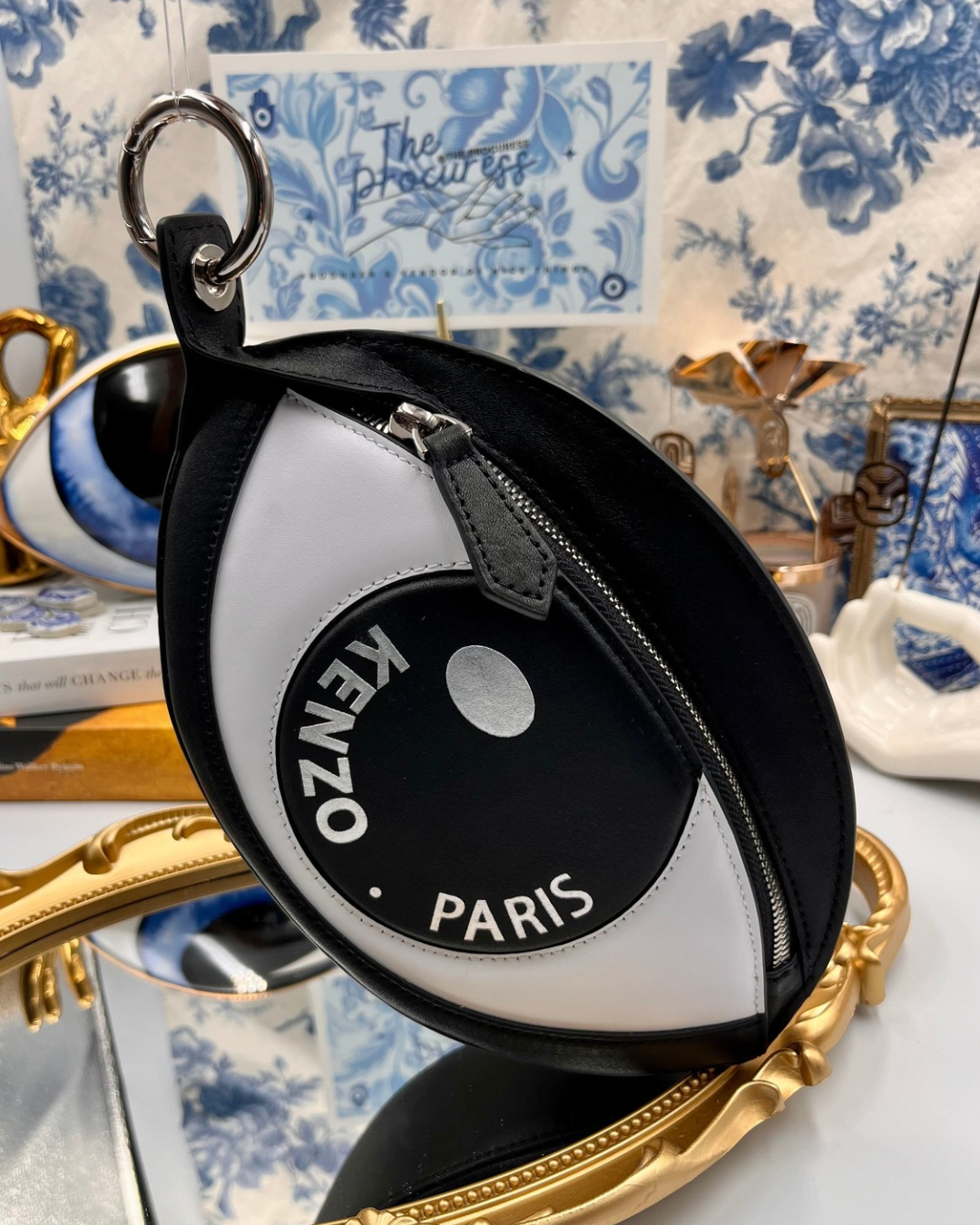 KENZO Kontact Eye leather clip pouch in black and white displayed in a decorative still life