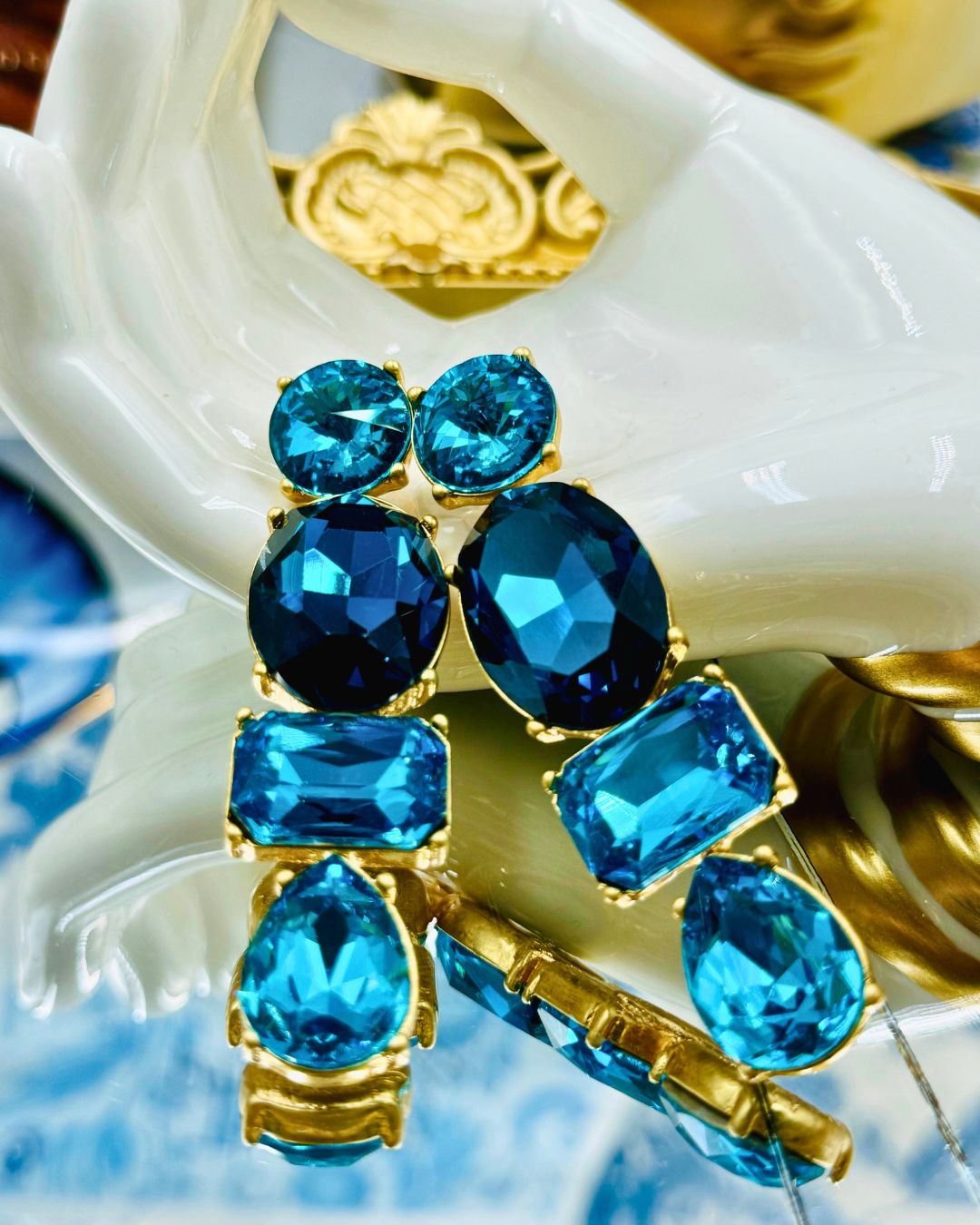 Mixed-cut blue Swarovski crystals in gold-tone settings on OSCAR DE LA RENTA earrings