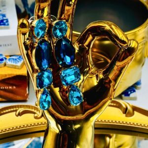 Posed view of OSCAR DE LA RENTA gold-tone blue crystal drop earrings