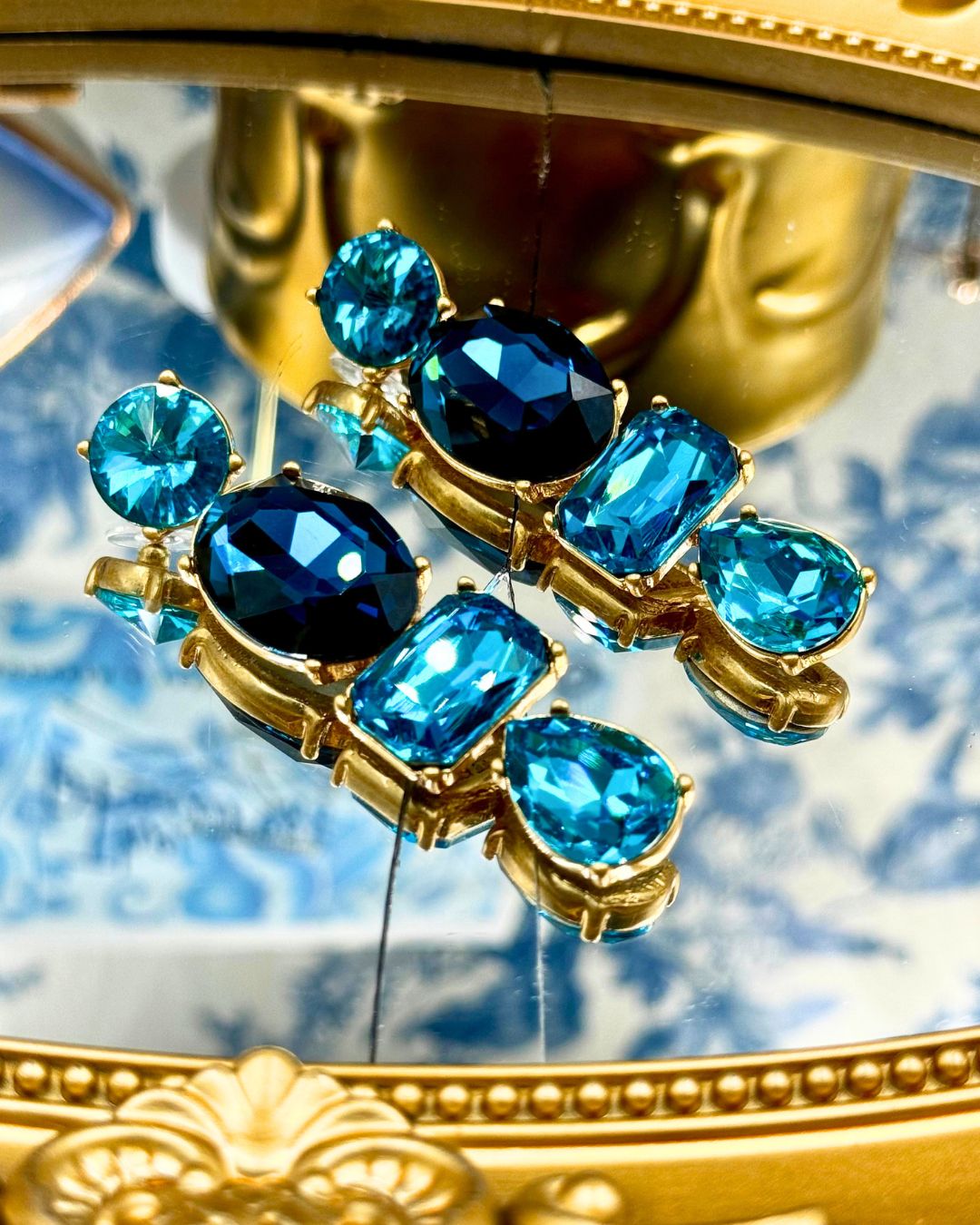 Front view of OSCAR DE LA RENTA gold-tone blue crystal drop earrings