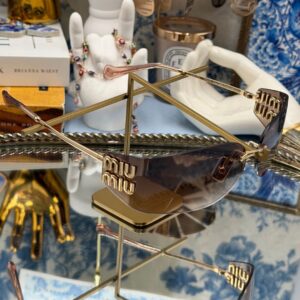 Angled view of MIU MIU A51S bronze rimless sunglasses