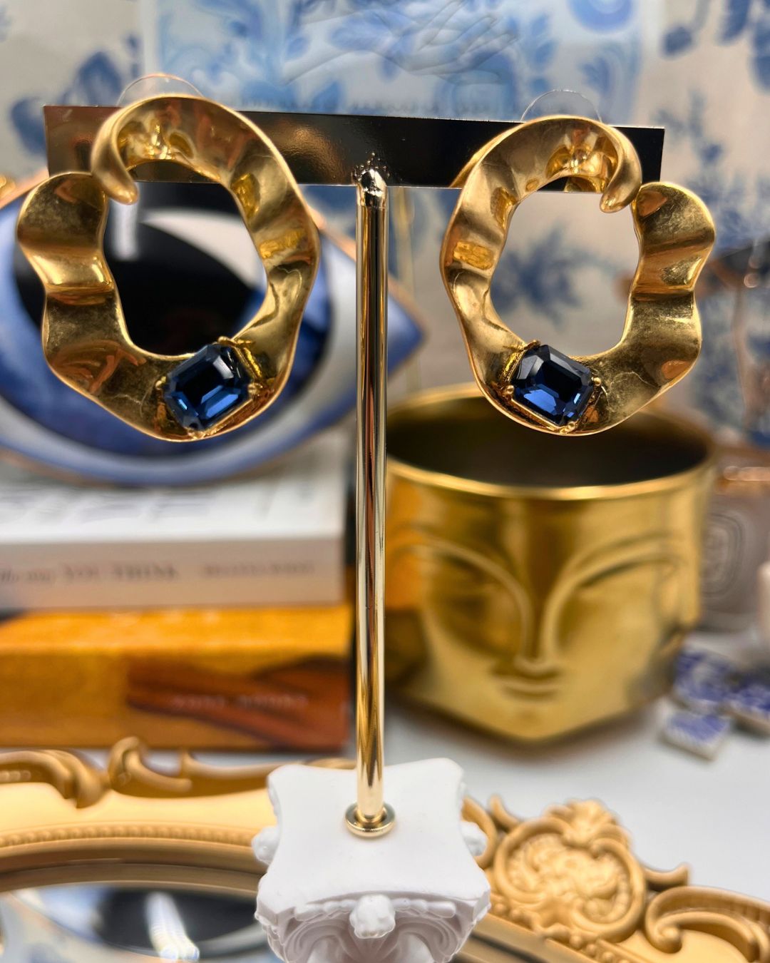Front view of OSCAR DE LA RENTA gold O earrings with blue glass stones