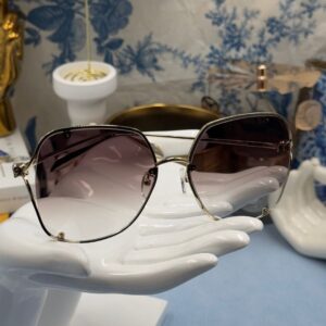 ALEXANDER McQUEEN AM0366S butterfly sunglasses in gold-tone metal with brown gradient lenses, folded view