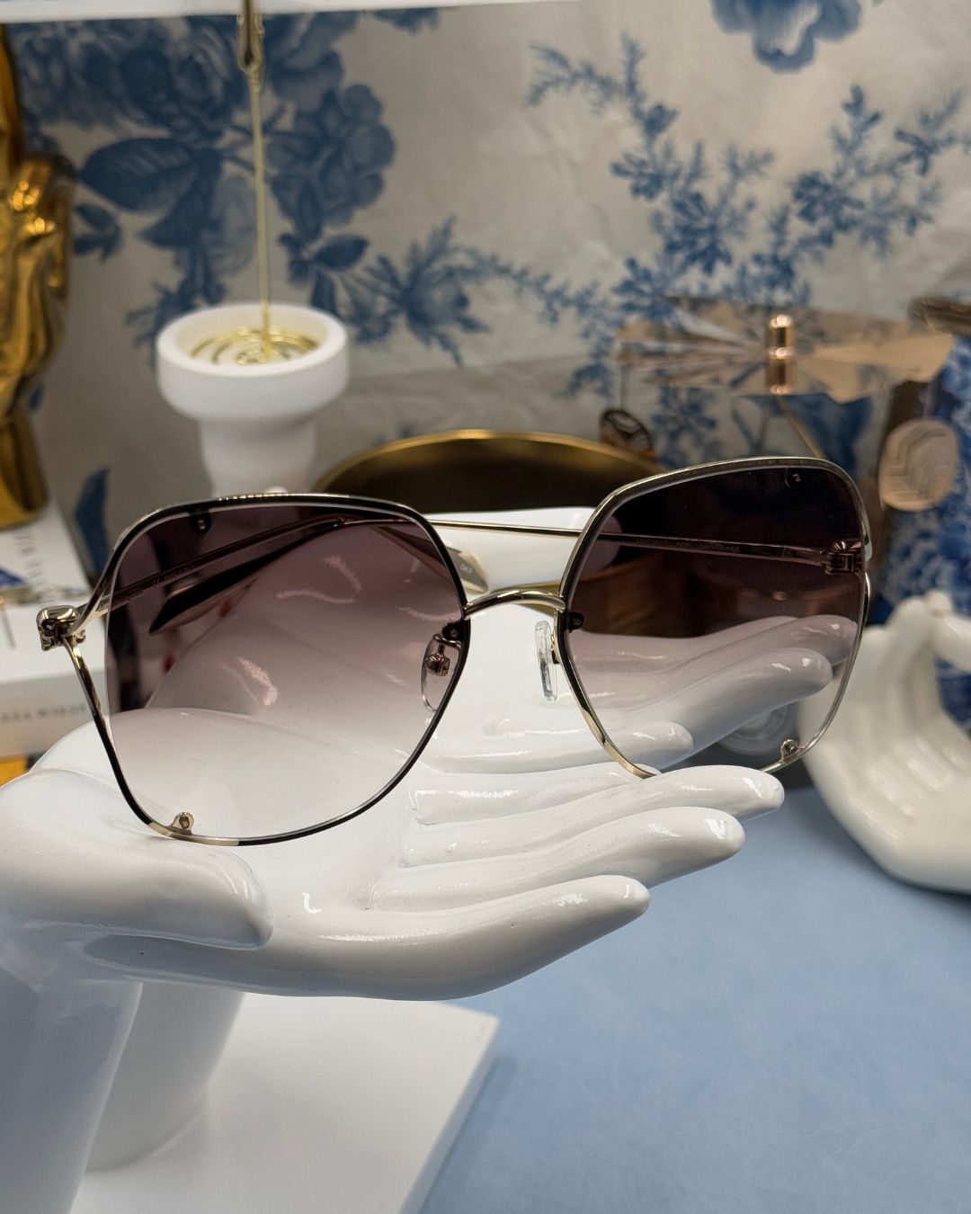 ALEXANDER McQUEEN AM0366S butterfly sunglasses in gold-tone metal with brown gradient lenses, folded view