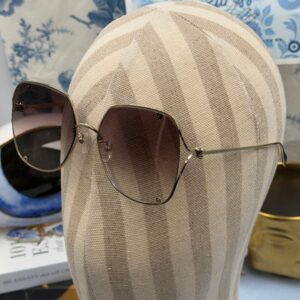 ALEXANDER McQUEEN AM0366S butterfly sunglasses in gold-tone metal with brown gradient lenses, modelled view