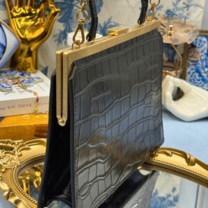 Angled view of black OROTON Icon Frame Croco Clutch