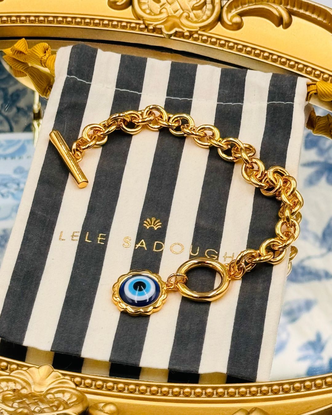 LELE SADOUGHI striped pouch included with Evil Eye Charm Bracelet