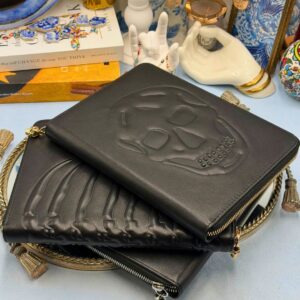 ALEXANDER McQUEEN black embossed leather zip portfolios in Skull Silver, Ribcage Gold and Skull Gold designs