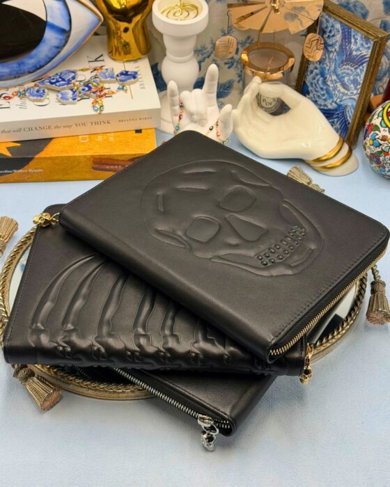 ALEXANDER McQUEEN black embossed leather zip portfolios in Skull Silver, Ribcage Gold and Skull Gold designs