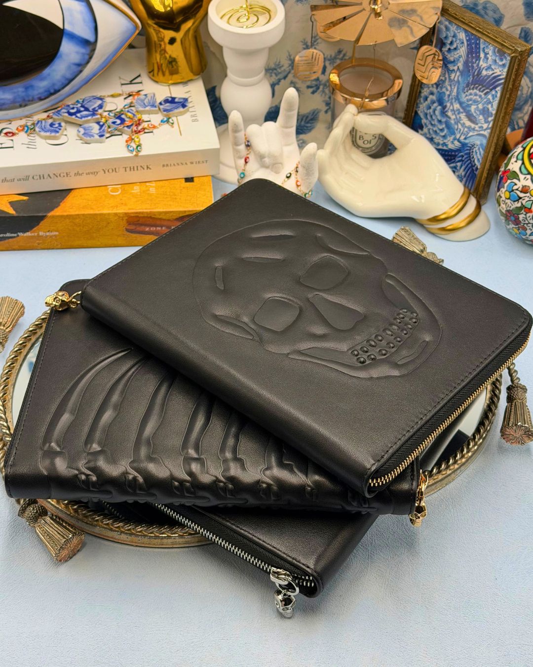 ALEXANDER McQUEEN black embossed leather zip portfolios in Skull Silver, Ribcage Gold and Skull Gold designs