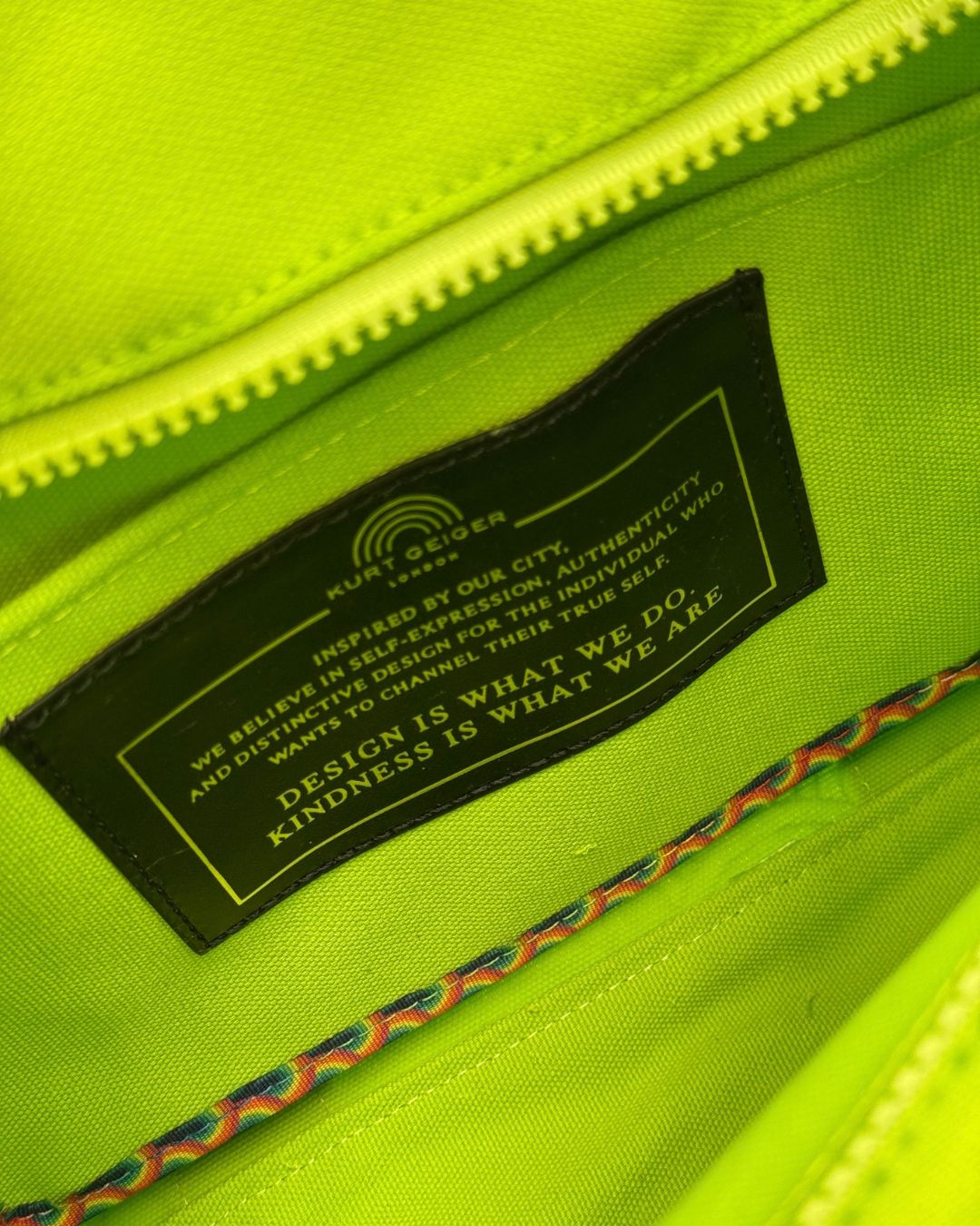 Interior label tag of KURT GEIGER LONDON Southbank Tote Bag in lime canvas with rainbow print