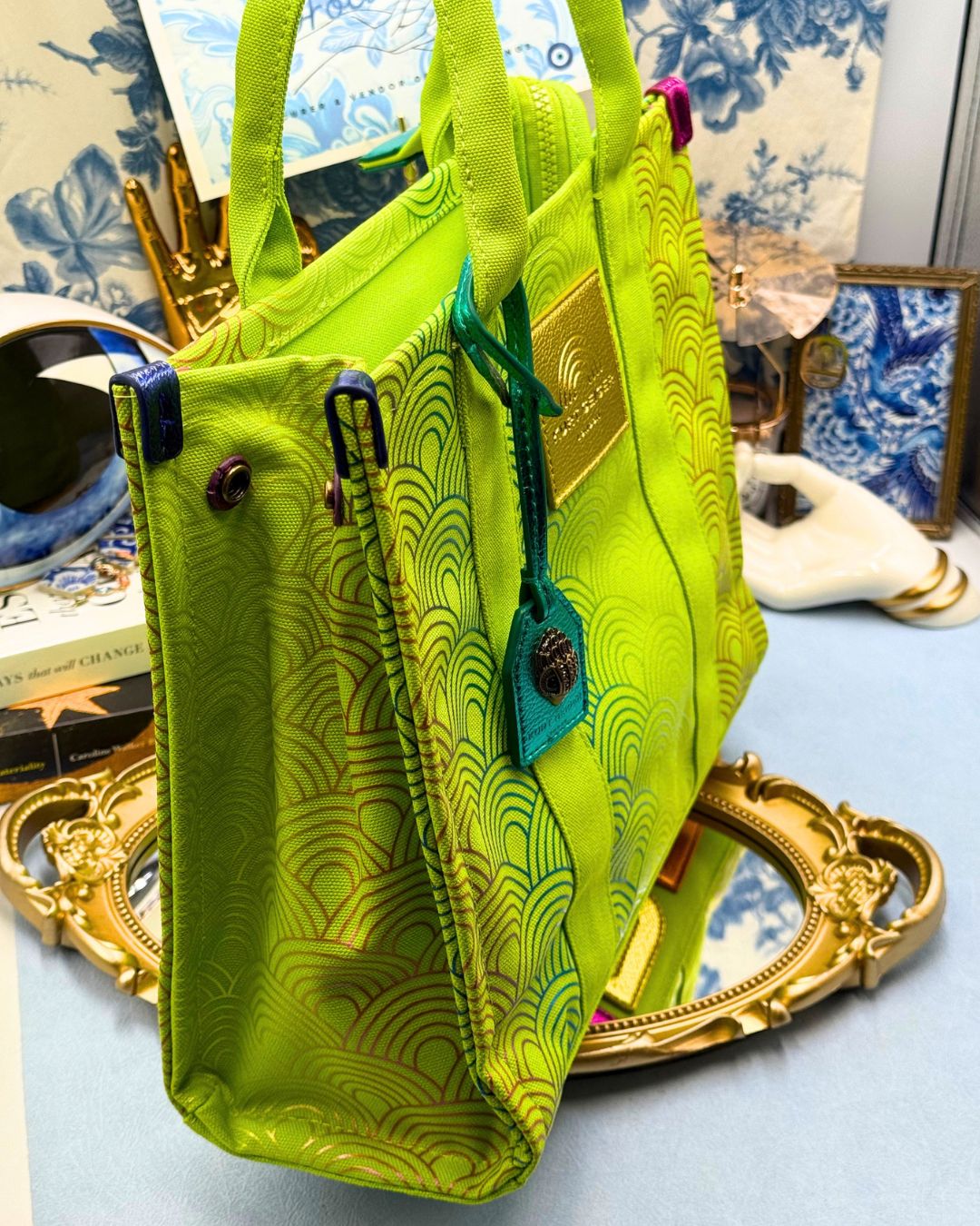 Side view of KURT GEIGER LONDON Southbank Tote Bag in lime canvas with rainbow print wide side poppers released