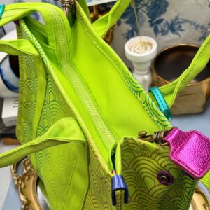 View of zipper of Side view of KURT GEIGER LONDON Southbank Tote Bag in lime canvas with rainbow print wide side poppers released